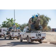 Des casques bleus burkinabè s'apprêtent à patrouiller à bord de leurs pick-up dans les rues de Tombouctou, au Mali.
