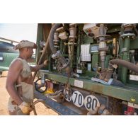 Un logisticien du Service des essences des armées (SEA) vérifie le débit de sortie de carburant d'un camion citerne polyvalent de 10m3 (CCP 10m3) à Gao, au Mali.