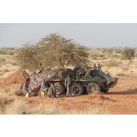 Des gendarmes maliens bivouaquent autour de leur véhicule BTR-60 PB en poste avancé autour de Gao, au Mali.