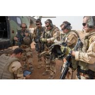 Un pilote du 5e régiment d'hélicoptères de combat (5e RHC) dirige un briefing auprès du groupement de commandos de montagne (GCM) avant de partir en mission à bord d'un hélicoptère Puma SA-330 à Gao, au Mali.