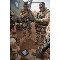 Un pilote du 5e régiment d'hélicoptères de combat (5e RHC) dirige un briefing auprès du groupement de commandos de montagne (GCM) avant de partir en mission à bord d'un hélicoptère Puma SA-330 à Gao, au Mali.