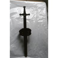 [Algérie, 1958-1961. Une épée posée sur une bâche en plastique.]
