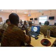 Des officiers des différentes armées assistent à un point de situation des opérations au poste de commandement conjoint de la force du G5 Sahel à Niamey, au Niger.