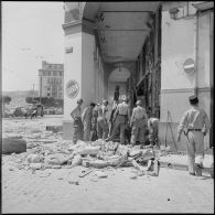 Déblaiement des débris d'un immeuble détruit par une explosion à Alger.