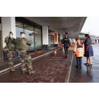 Des soldats sécurisent une zone de colis suspect aux côtés d'agent aéroportuaires à Orly.