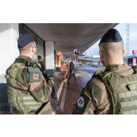 Des soldats sécurisent une zone de colis suspect aux côtés d'un agent cynotechnique de la sûreté aérienne et aéroportuaire à Orly.