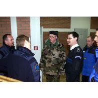 Discussion entre le général Tartinville, des policiers et des gendarmes français à l'école de police.