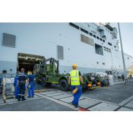 Des marins guident le chargement d'un camion porteur polyvalent terrestre (PPT) à bord du bâtiment de projection et de commandement (BPC) Le Tonnerre à Toulon.