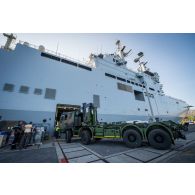 Des marins guident le chargement d'un camion porteur polyvalent terrestre (PPT) à bord du bâtiment de projection et de commandement (BPC) Le Tonnerre à Toulon.