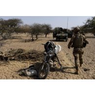 Des soldats du peloton de reconnaissance et d'intervention (PRI) inspectent une moto trouvée lors de leur reconnaissance de la région de Tessit, au Mali.