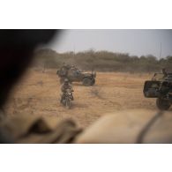 Un soldat du peloton de reconnaissance et d'intervention (PRI) achemine une moto Apsonic AP 125-50 trouvée lors d'une reconnaissance de la région de Tessit, au Mali.