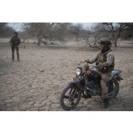 Un soldat du peloton de reconnaissance et d'intervention (PRI) achemine une moto Apsonic AP 125-50 trouvée lors d'une reconnaissance de la région de Tessit, au Mali.
