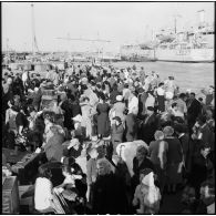Les ressortissants italiens, grecs et yougoslaves patientent sur le quai avant leur embarquement sur le navire-hôpital Ascania.