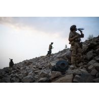 Un soldat se désaltère lors de l'ascension d'un piton rocheux dans la région de Mopti, au Mali.