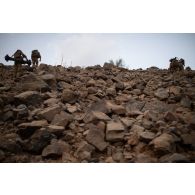 Des soldats portent un missile moyenne portée (MMP) en haut d'un piton rocheux dans la région de Mopti, au Mali.