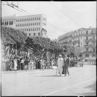 Cérémonie du 14 juillet à Alger. Un mutilé de guerre passe devant la tribune officielle.