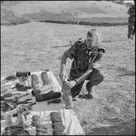 Un béret bleu examine un obus de 165 mm capturé aux rebelles.