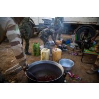 Des soldats nigériens préparent le repas au sein d'une base opérationnelle avancée temporaire (BOAT) à Diamon, au Burkina Faso.