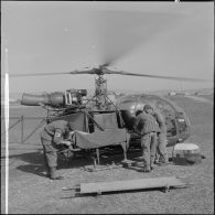 Deux brancardiers amènent à un hélicoptère de transport sanitaire (alouette II) un français musulman qui sera évacué à l'hôpital de Sétif.