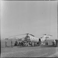 L'équipage de l'hélicoptère de l'hélicoptère Piasecki H-21 monte la tente du médecin sous le ragard des habitants du douar.