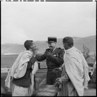 Le colonel Destanches s'entretient avec des hommes au marché de Tizi Ouzou.
