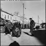 L'adjudant Bardon du quartier général (QG) de la 10ème division des parachutistes (DP) marchandant un tapis dans le village de Fort National.