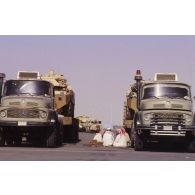 Repas au pied des véhicules de chauffeurs de camions Mercedes porte-chars saoudiens chargés de convoyer des blindés de reconnaissance AMX-10 RC, marqués de l'insigne du 1er RS (régiment de spahis), sur un quai du port de Yanbu.