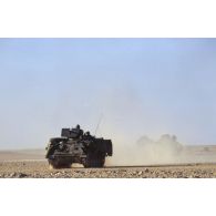 En ZDO (zone de déploiement opérationnel) Olive, un blindé M901 américain en tête d'un convoi roule dans le désert.