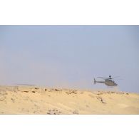 Atterrissage d'un hélicoptère américain de reconnaissance et d'observation Bell OH-58 D Kiowa dans le désert en ZDO (zone de déploiement opérationnel) Olive.