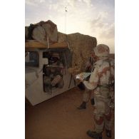 En ZDO (zone de déploiement opérationnel) Olive, des soldats américains mangent leur plateau-repas dans le désert.
