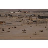 Vue aérienne du fort, de bâtiments et de rues de la ville d'Al Salman avec des véhicules de la division Daguet.