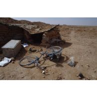 Devant un abri fortifié irakien abandonné par les soldats, un vélo gît au sol.