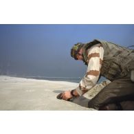 Un sapeur parachutiste du 17e RGP (régiment du génie parachutiste) en tenue pare-éclats démine la plage de Koweit City.