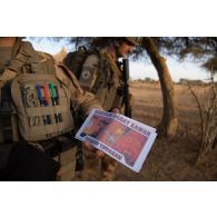 Des soldats distribuent des tracts afin de sensibiliser les habitants du village de Tin-Akoff, au Burkina Faso.