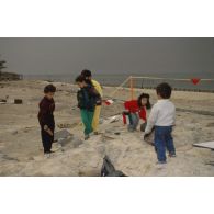 Des enfants koweitiens jouent sur la plage et manipulent des munitions irakiennes désamorcées lors de la présentation à la population civile du travail de déminage accompli sur les plages de Koweit City.