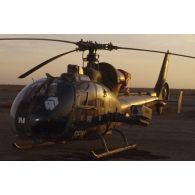 Le soir, un hélicoptère de combat Gazelle au sol dans le désert.