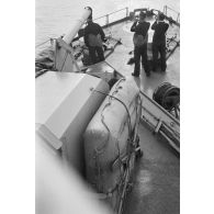 Devant un canon de 10,5 cm SK L/45 installé à la proue d'un dragueur de mines (Minensuchboot), des marins allemands observent aux jumelles.