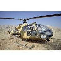 Hélicoptère de combat Gazelle émirati posé dans le désert.