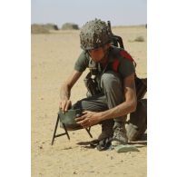 Un soldat du génie met en place une mine antipersonnel de type MI AP ED (mine antipersonnel à effet dirigé) dans le désert.