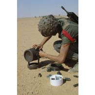 Un soldat du génie manipule une mine de type MI AC AH F1 (mine antichar à action horizontale).