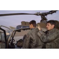 L'équipage d'un d'hélicoptère de combat Gazelle Hot du 5e RHC s'entraide pour revêtir la tenue S-3P (survêtement de protection à port permanent) lors d'un exercice NBC.