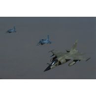 Un avion de combat Mirage F1-CR au premier plan et deux avions de combat Mirage 2000 au second plan en mission dans le ciel d'Arabie Saoudite, vus depuis un avion ravitailleur.