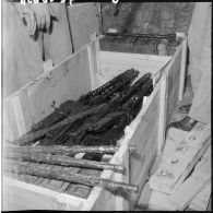 Une caissen en bois contenant des armes et des explosifs.