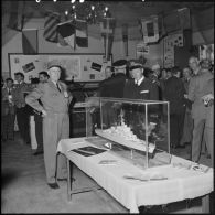 Le général d'armée Salan et l'amiral Auboyneau devant une maquette de bateau lors d'une exposition de la Marine à Alger.
