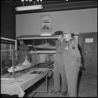 Le général d'armée Salan devant une maquette de bateau lors d'une exposition de la Marine à Alger.