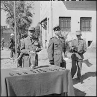 Le général Salan et le colonel Marquet devant la table où se trouvent les prix.