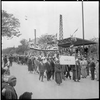 Défilé de la population civile de Bedeau avec banderolles devant les autorités.