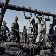 Des soldats français et des hommes autour d'un puits dans le village tchadien de Gambir.