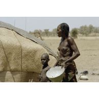 Une femme tchadienne et son enfant devant leur tente dans le village nomade d'Alifen.