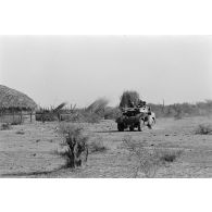 Une automitrailleuse du 1er régiment de hussards parachutistes (RHP) traverse un village tchadien.